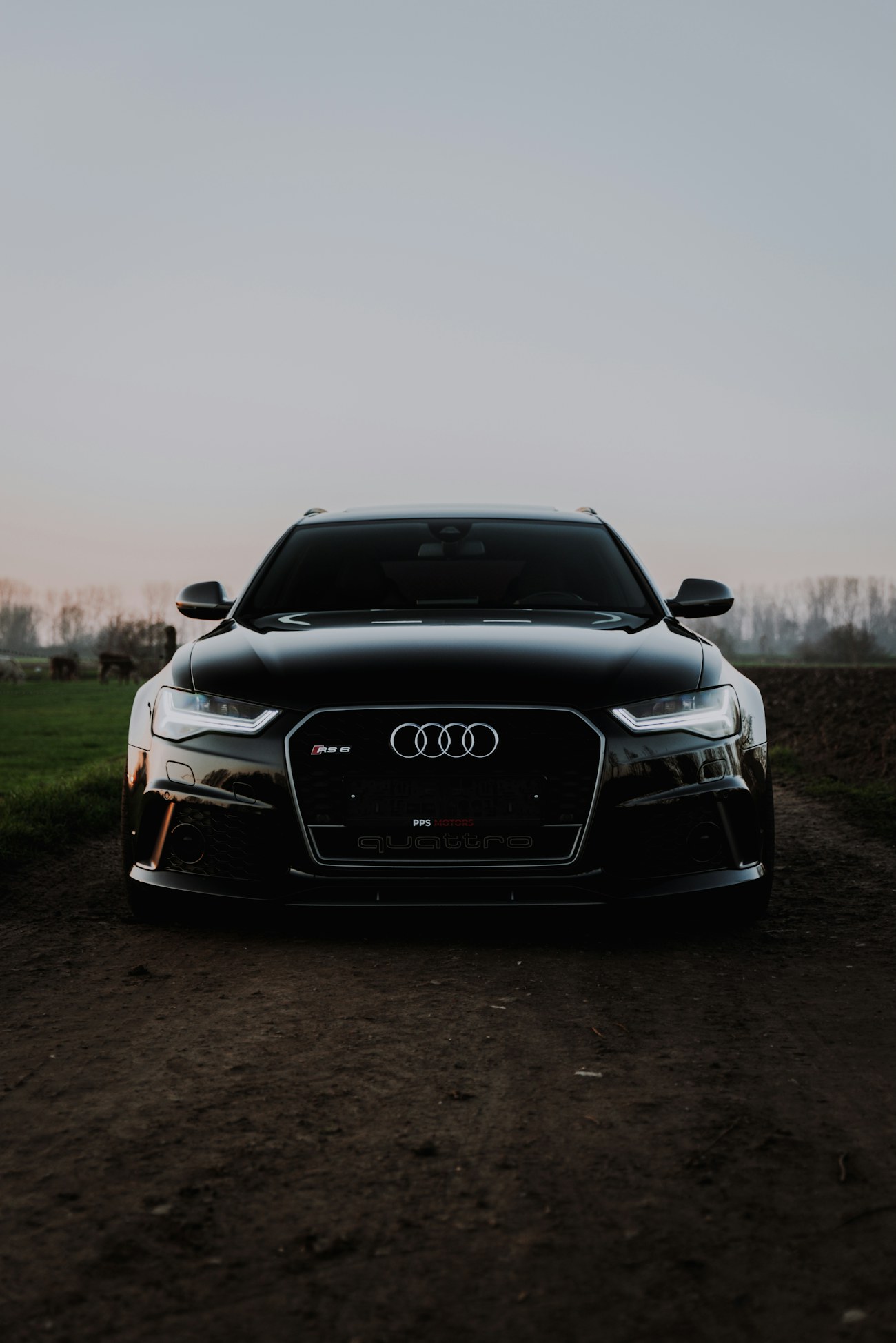Audi RS6 Avant в сумерках на просёлочной дороге